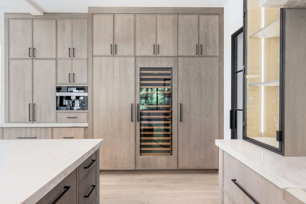 Kitchen cabinetry with wine storage and built-in ovens in a custom home built by VIBE Luxury Homes in Brookhaven, Atlanta