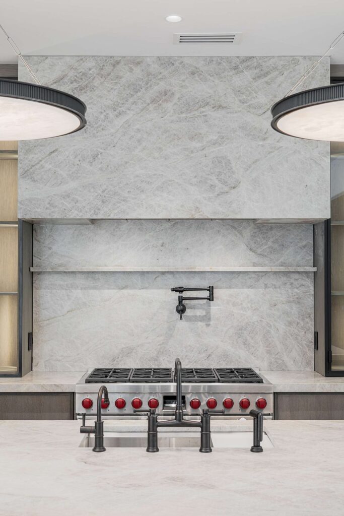 Range and marble backsplash with pot filler in a custom home built by VIBE Luxury Homes in Brookhaven, Atlanta